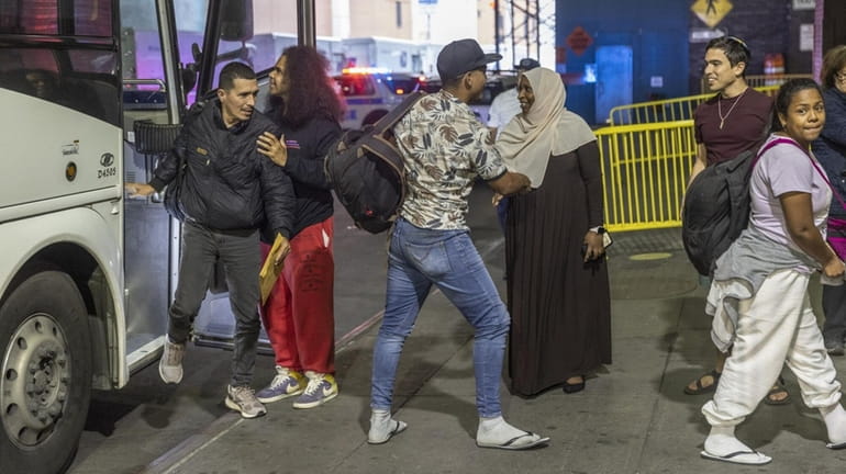 Migrants arrive at the Port Authority Bus Terminal in Manhattan after...