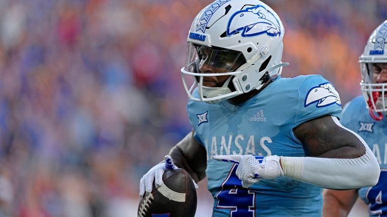 Kansas running back Devin Neal (4) celebrates with after scoring...