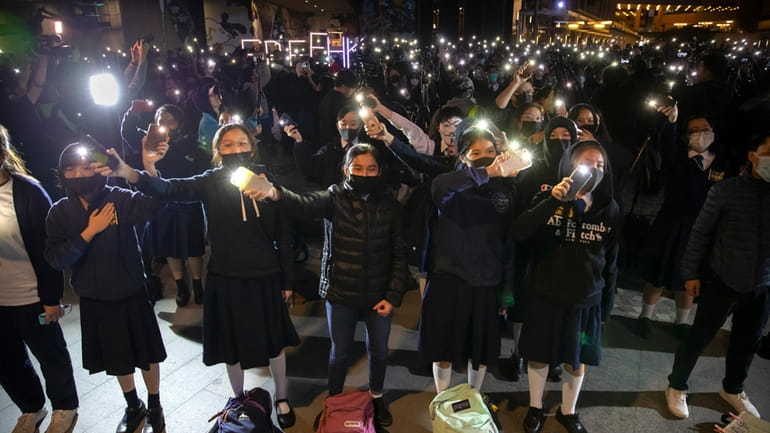 Protesters wave their smartphones as they sing "Glory to Hong...
