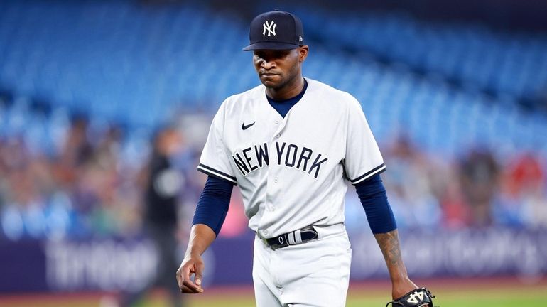 Domingo German #0 of the Yankees walks to the dugout in...