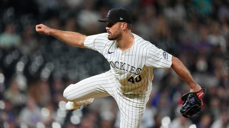 Colorado Rockies relief pitcher Tyler Kinley watches a throw to...