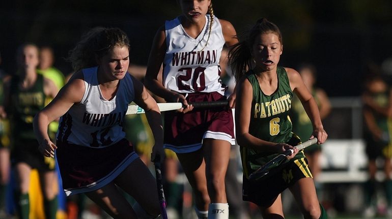 Alexa Kidd of Ward Melville, right, moves a ball downfield...