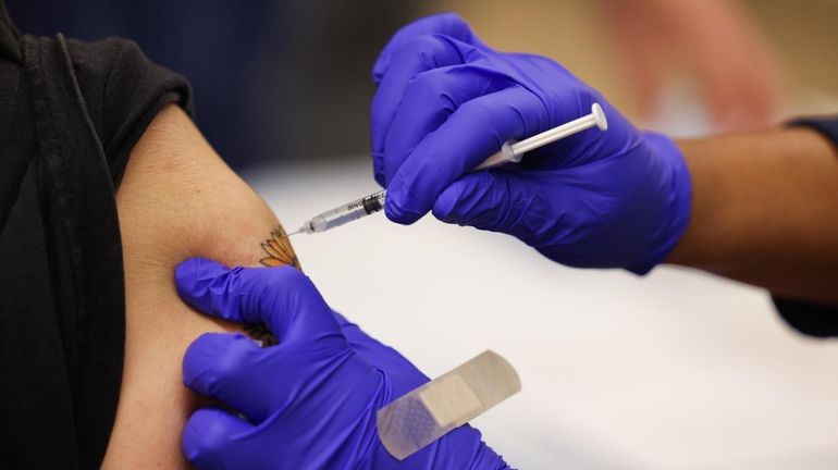 A COVID-19 vaccine shot is administered at the Mount Sinai South...