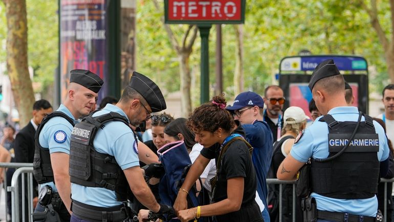 Officials inspect items at a security checkpoint in Paris, France,...