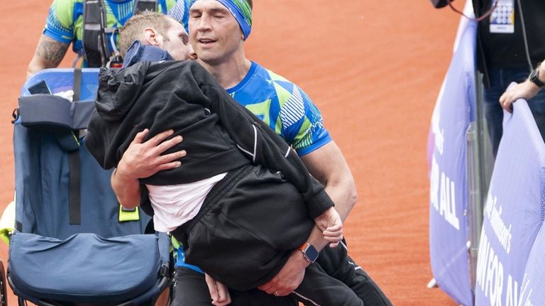 Kevin Sinfield carries Rob Burrow as he crosses the finish...