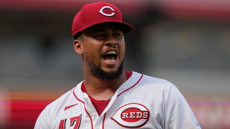 Reds starting pitcher Frankie Montas calls out as he walks...