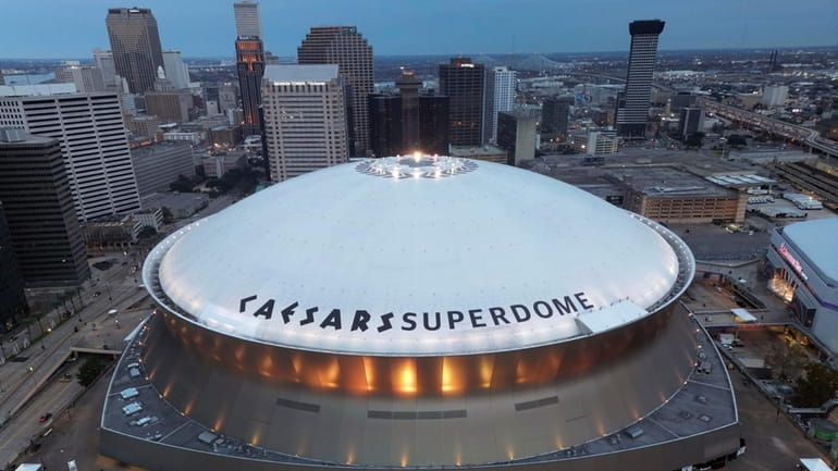 The Superdome stands with the New Orleans skyline in the...