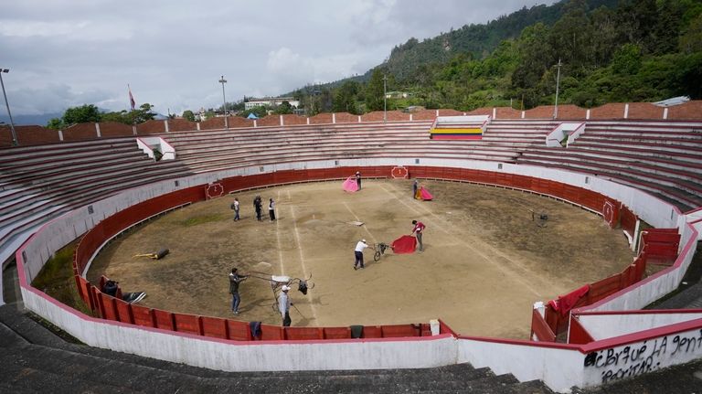 Colombian bullfighter Sebastian Caqueza, 33, center, trains the the bullring...