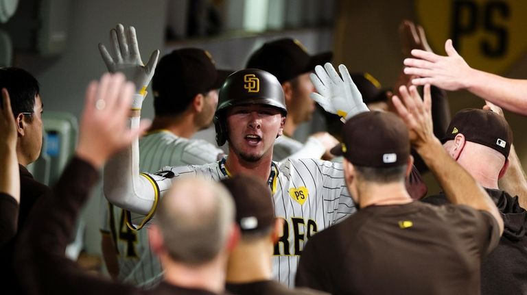 San Diego Padres' Jackson Merrill is congratulated in the dugout...