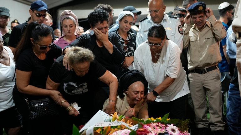 The mother, center, of Petty Officer 1st Class David Moshe...