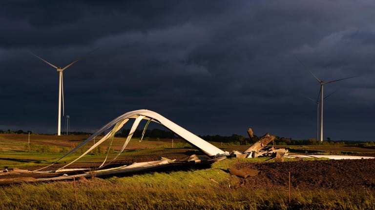 The remains of a tornado-damaged wind turbine touch the ground...