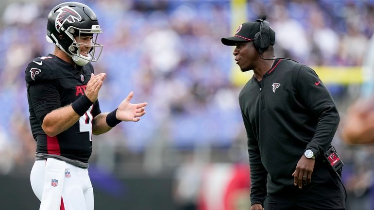 Atlanta Falcons quarterback Taylor Heinicke and head coach Raheem Morris...