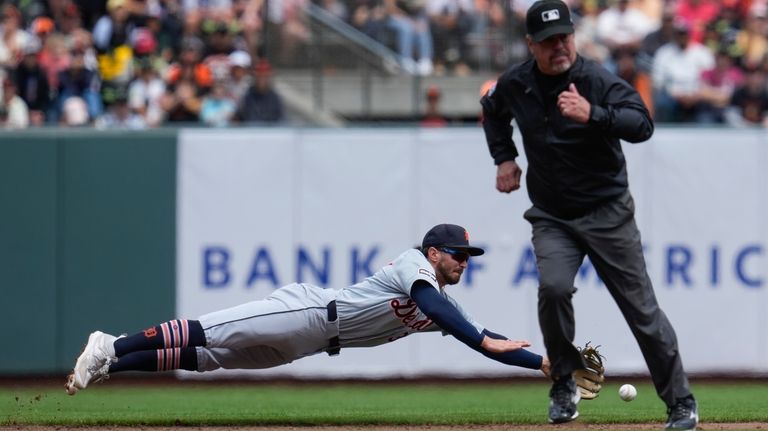 Detroit Tigers shortstop Zach McKinstry, left, is unable to catch...