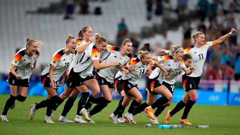 Germany players celebrate after wining a women's quarterfinal soccer match...