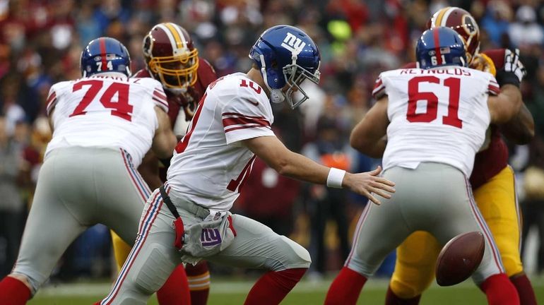 Quarterback Eli Manning #10 of the New York Giants drops...