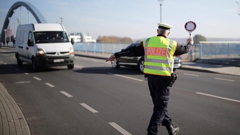 A officer of German Federal Police stops a van to...