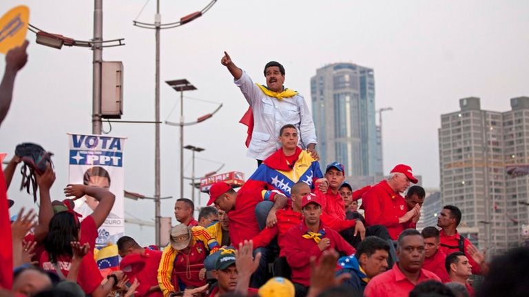 Venezuela's acting President Nicolas Maduro greets supporters as he arrives...