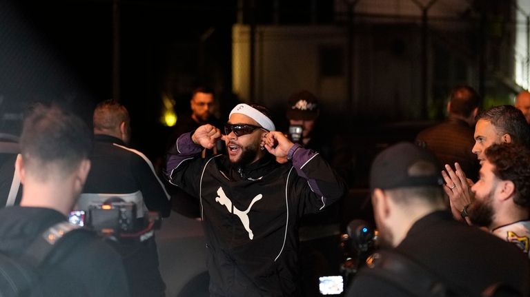 Soccer player Memphis Depay, center, cheers supporters upon arriving at...