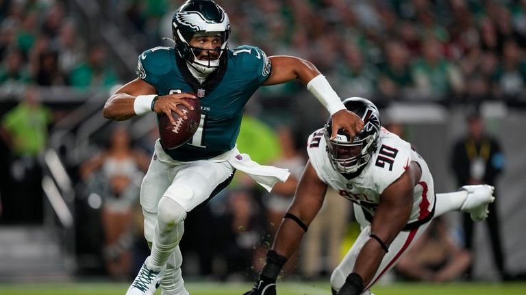 Philadelphia Eagles quarterback Jalen Hurts (1) runs past Atlanta Falcons...