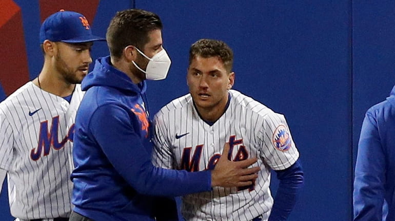 Albert Almora Jr. #4 of the Mets is checked on after...