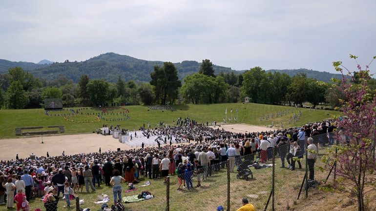 People watch the official ceremony of the flame lighting for...