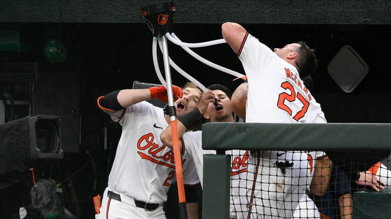 Baltimore Orioles' Gunnar Henderson, left, celebrates his grand slam against...