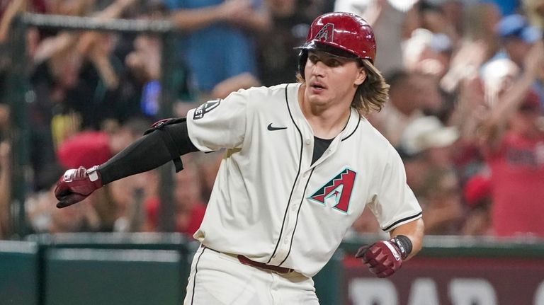 Arizona Diamondbacks' Jake McCarthy gestures towards the dugout after knocking...