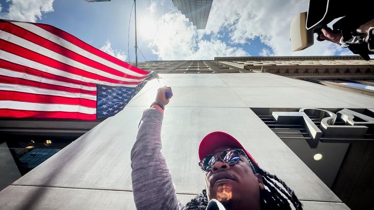 A supporter of former President Donald Trump waves an inverted...