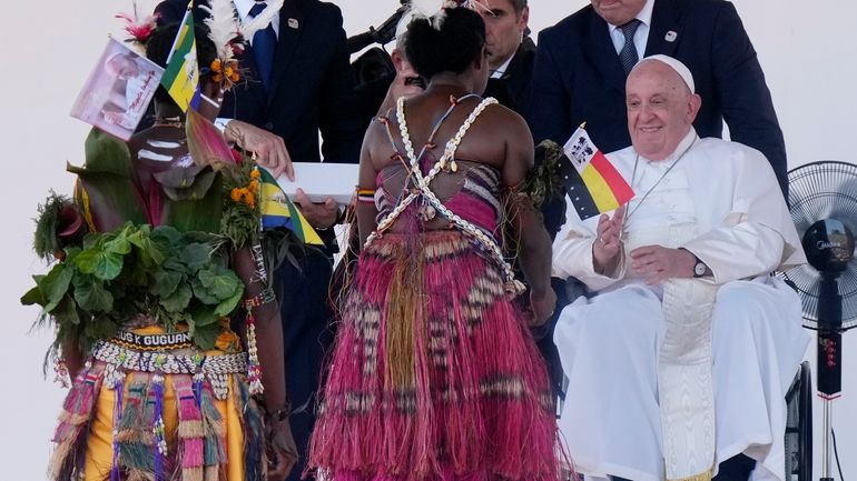 Pope Francis meets with people in traditional dress after giving...