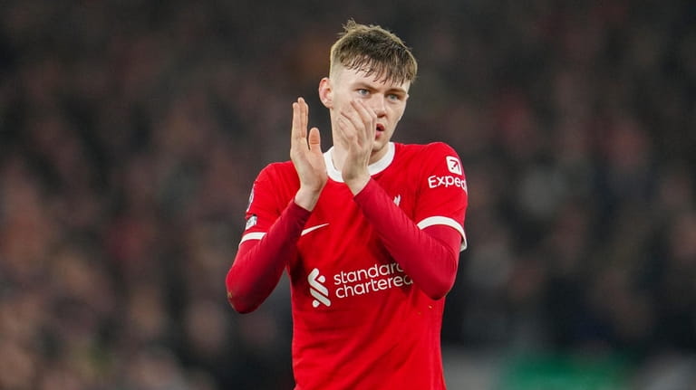 Liverpool's Conor Bradley applauds as he leaves the pitch after...