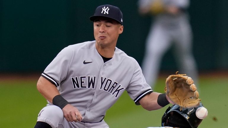 The Athletics' Esteury Ruiz steals second base next to Yankees shortstop...