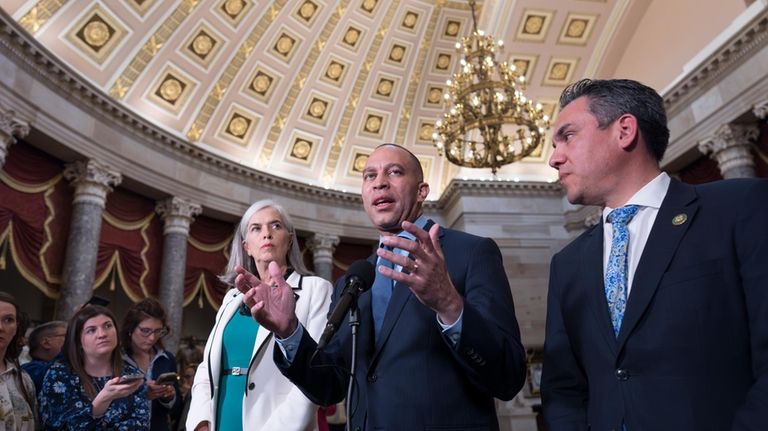 House Minority Leader Hakeem Jeffries, D-N.Y., center, flanked by Rep....