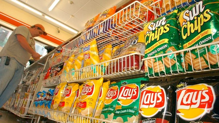 A customer makes a purchase at a convenience store in...