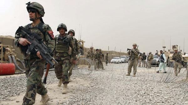 Afghan and U.S. soldiers are seen as a crowd gathers...