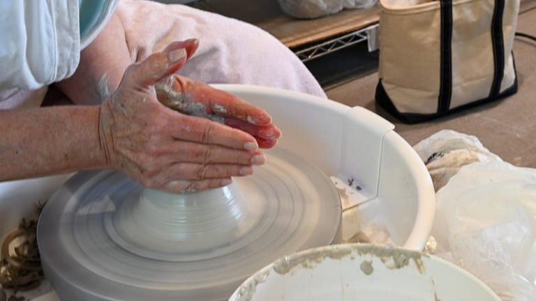 Karen Renna molds her project during a pottery class in...