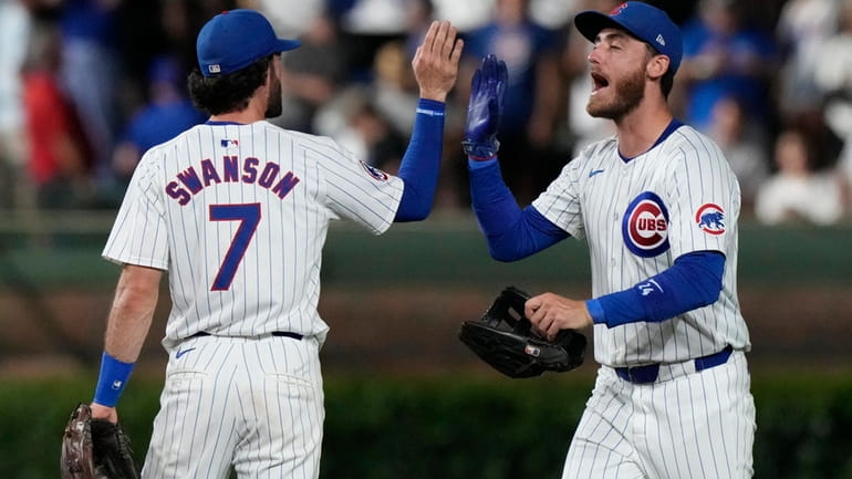 Chicago Cubs' Cody Bellinger, right, celebrates with Dansby Swanson after...