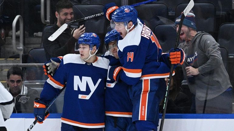 Islanders defenseman Alexander Romanov and center Bo Horvat congratulate left...