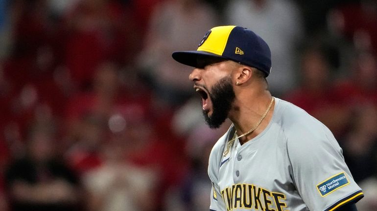 Milwaukee Brewers relief pitcher Devin Williams celebrates after striking out...