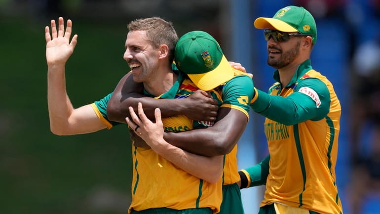 South Africa's Anrich Nortje, left, celebrates with teammates after the...