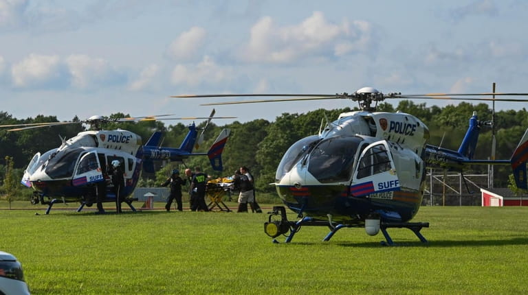 A patient is rushed to a helicopter on a nearby...