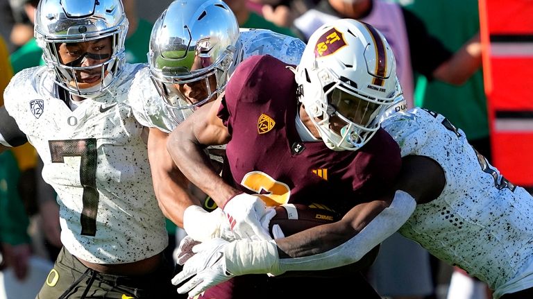 Arizona State wide receiver Elijhah Badger, front, is hit by...