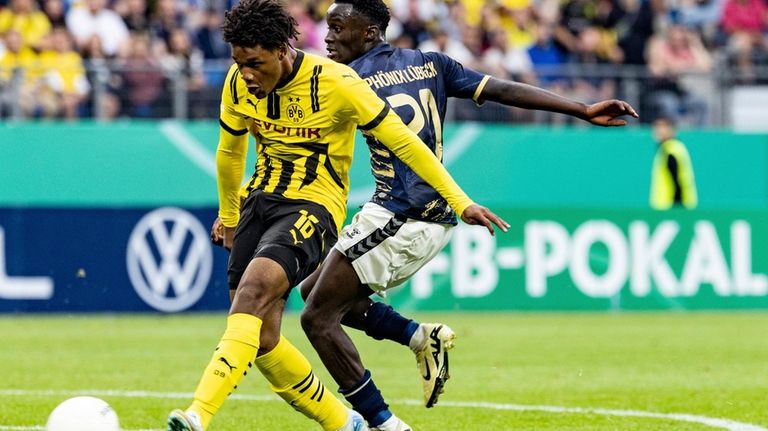 Dortmund's Julien Dienda Duranville, left, scores during the German Cup...