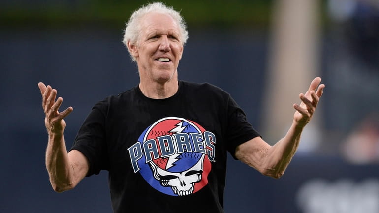 Former basketball player and sportscaster Bill Walton gestures after throwing...