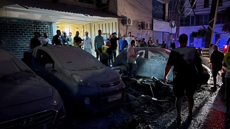 People inspect damaged cars in the southern suburbs of Beirut,...