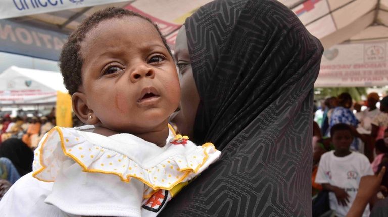 A woman waits to administer the malaria vaccine Oxford-Serum R21...