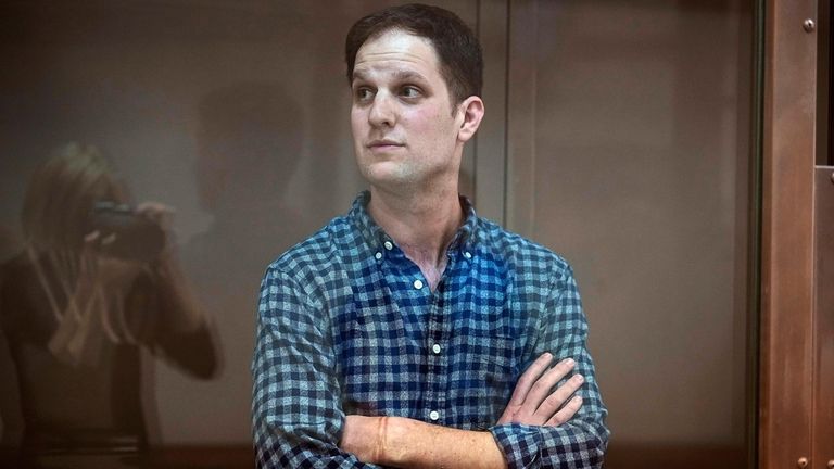 Wall Street Journal reporter Evan Gershkovich stands in a glass...