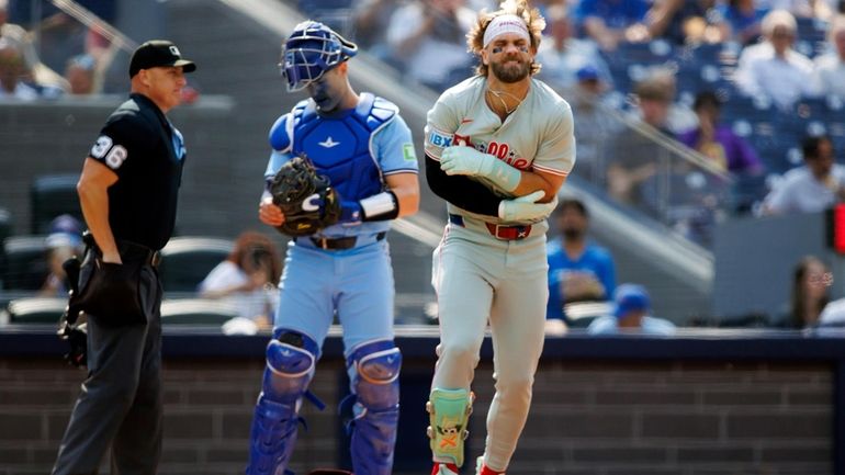 Philadelphia Phillies first base Bryce Harper holds his arm after...