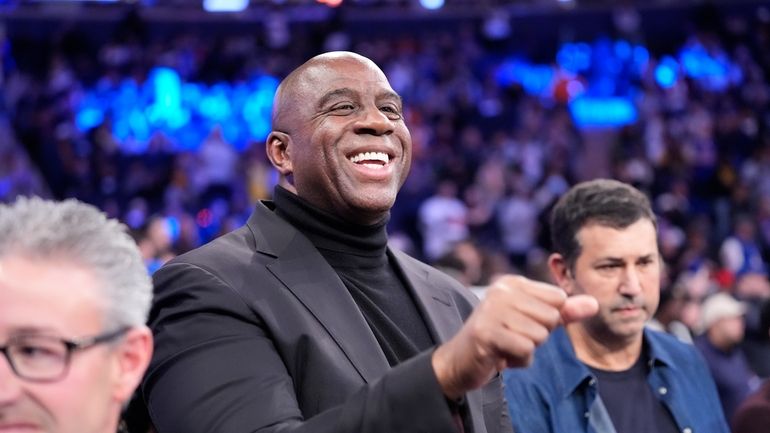 Magic Johnson waves to people before an NBA basketball game...