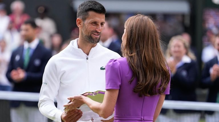 Novak Djokovic of Serbia receives his trophy from Kate, Princess...