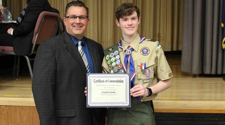 Joseph Candia, a junior at North Babylon High School, receives a...